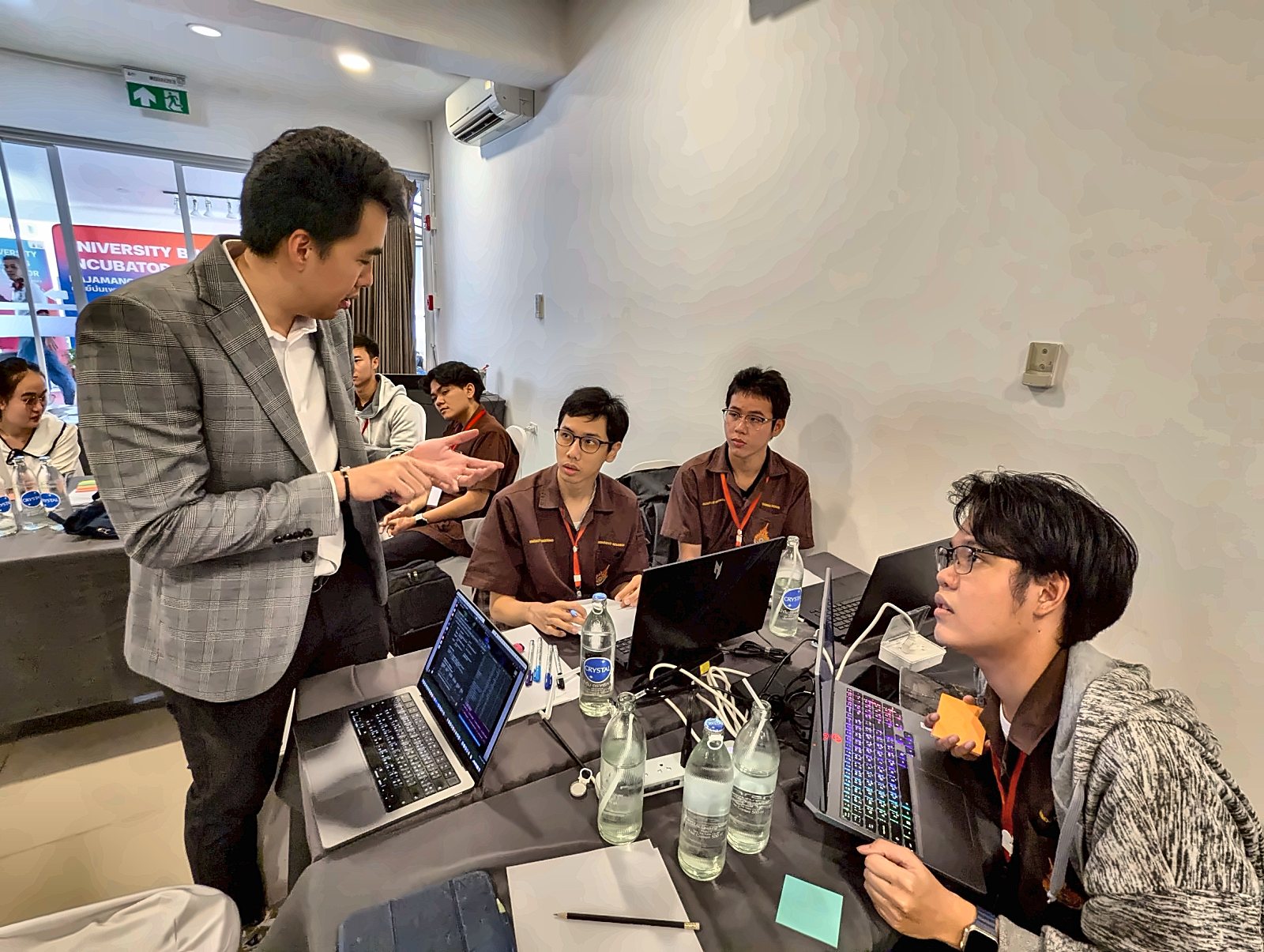 A mentor from the incubator giving our team feedback at our table